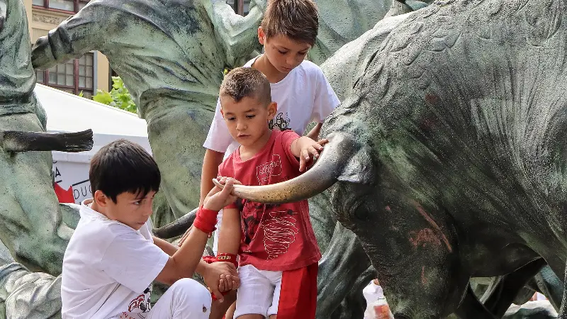 A child reaches out to one of the bronze bulls (2018).