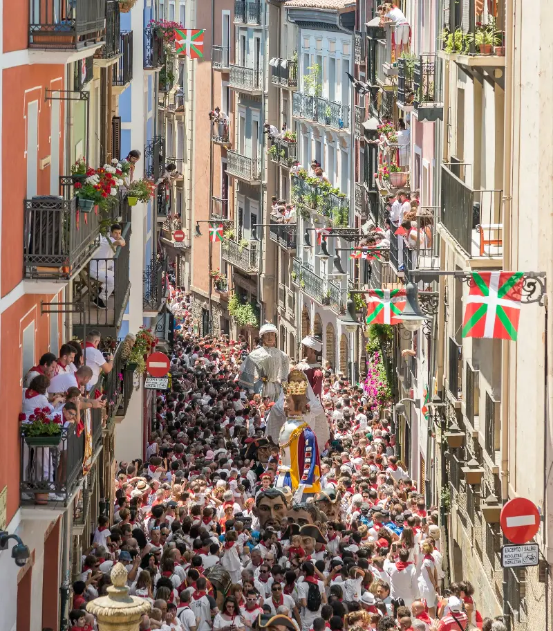Gente de blanco y rojo esperando en la calle.