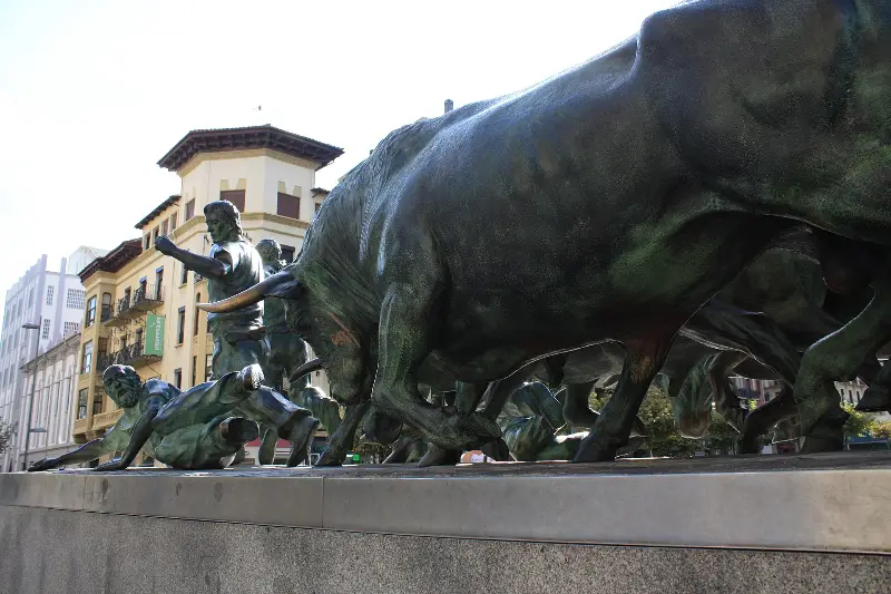 A bronze bull charging in the Encierro monument.