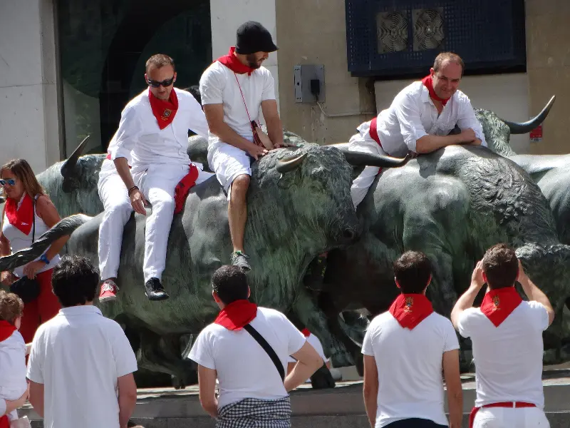 Revellers climb the bull sculpture of the Encierro monument (2014).