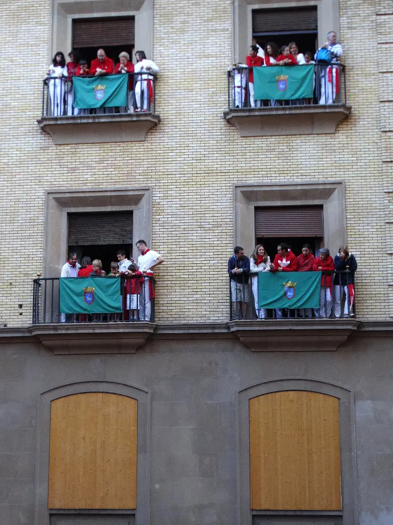 Espectadores en balcones engalanados para San Fermín (2014).