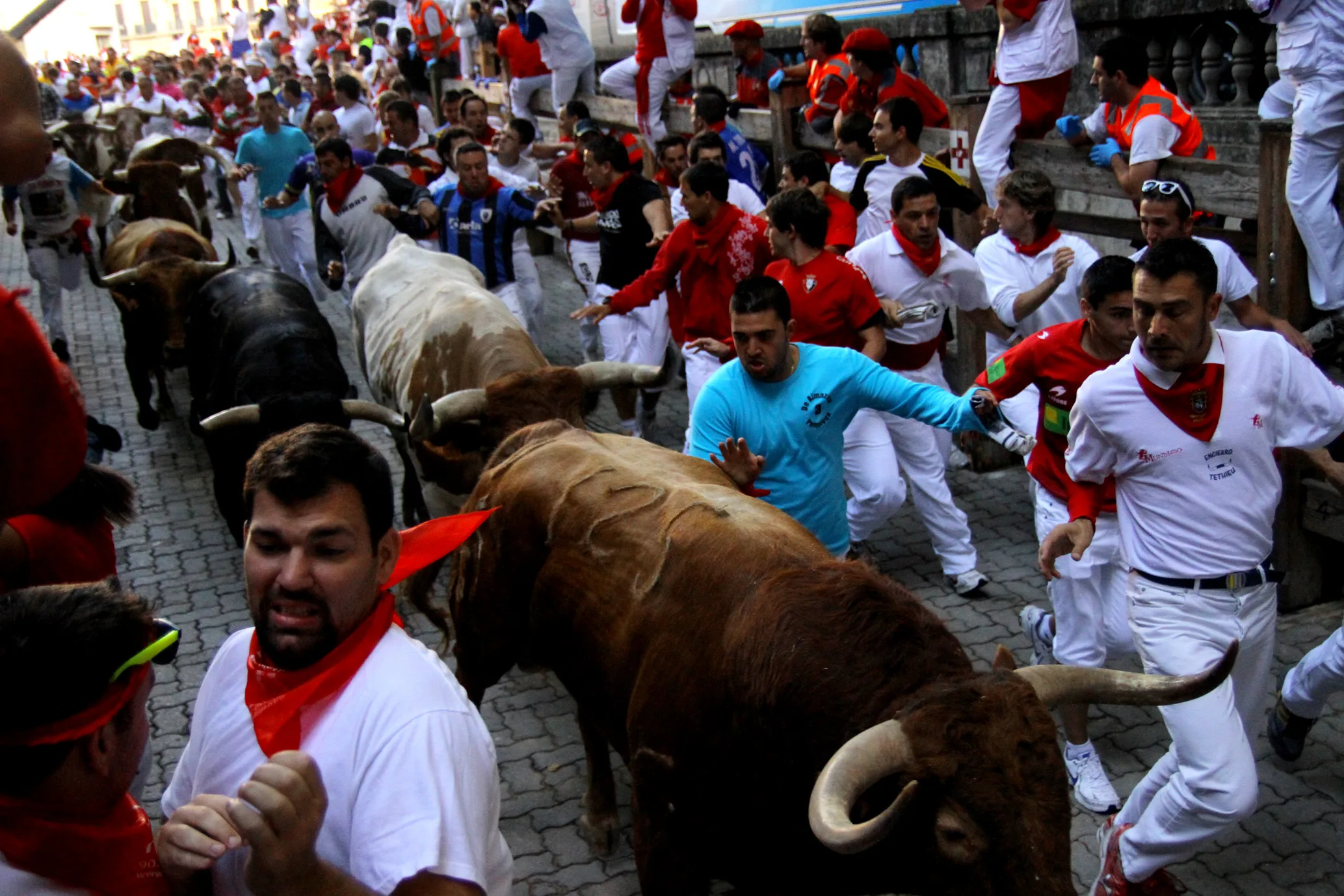 Corredores a pocos metros de los toros en las calles de Pamplona